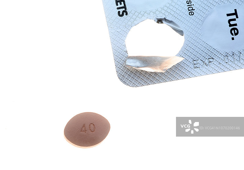 从包装中取出的他汀类药物药丸，准备服用。图片素材