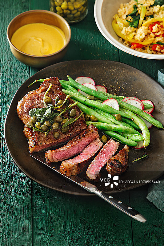 搭配芥末酱、蔬菜、香草和刺山柑的牛排图片素材