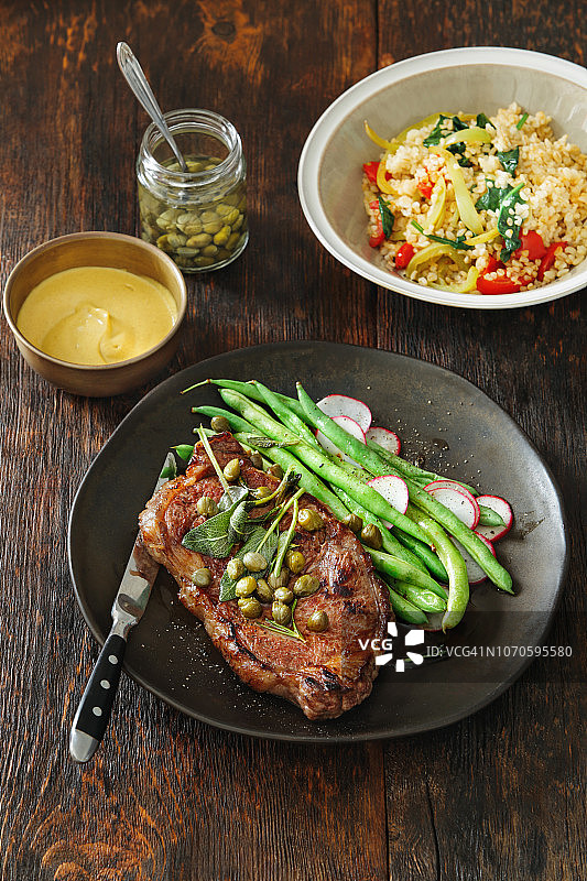 搭配芥末酱、蔬菜、香草和刺山柑的牛排图片素材