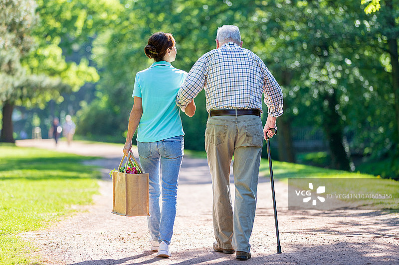 公园里照顾老年男性的妇女图片素材