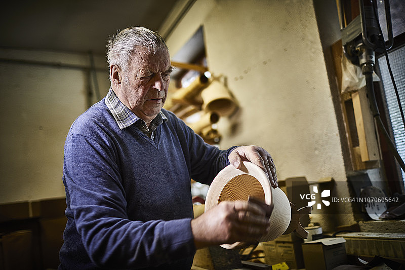 在工作室用砂纸制作阿尔卑斯号角的年长男人图片素材