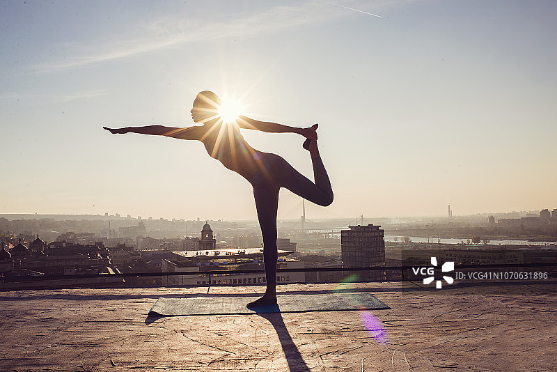 在屋顶上做瑜伽的女人图片素材