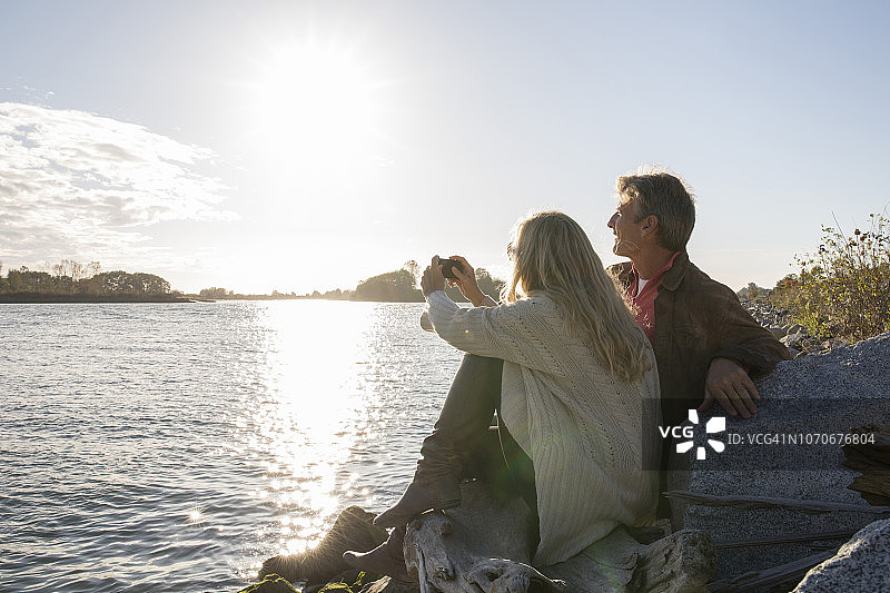 情侣在弗雷泽河上用手机拍照图片素材