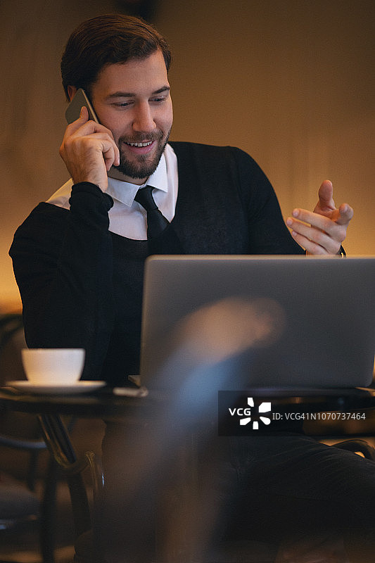 在咖啡吧使用电脑的年轻商人图片素材