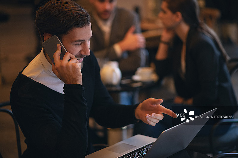 在咖啡吧使用电脑的年轻商人图片素材