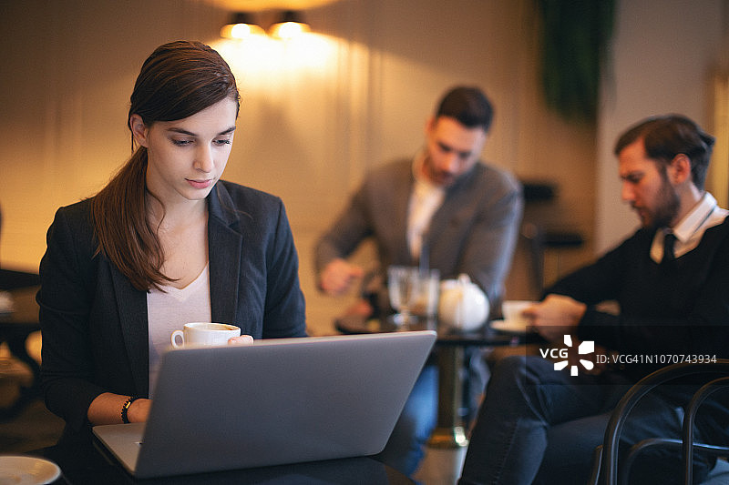 在咖啡吧工作的年轻女商人图片素材