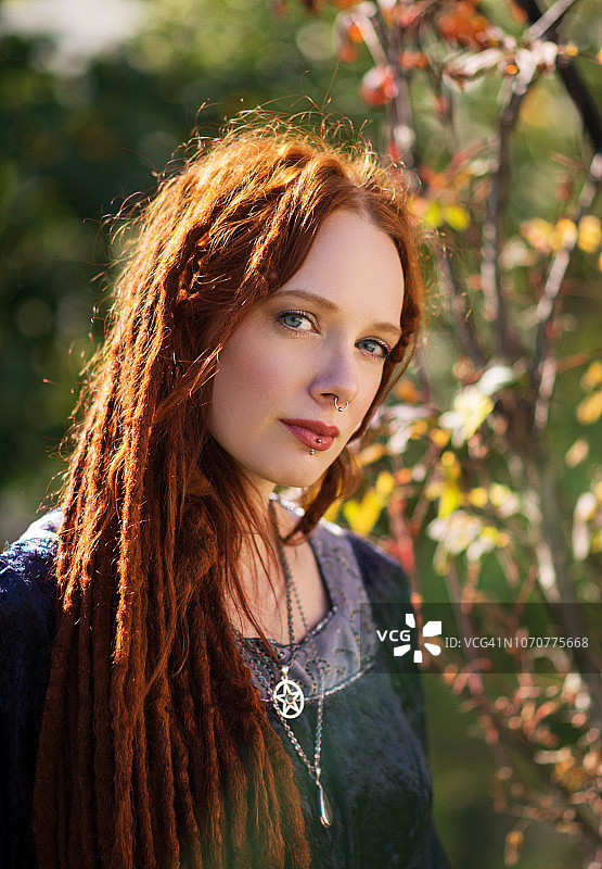 秋日花园里长着红色长发的女人的头部和肩膀图片素材