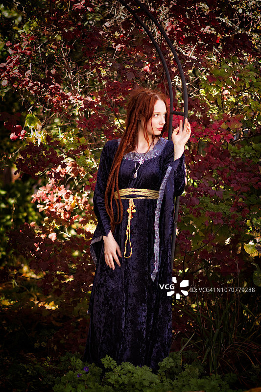 秋日花园里的红色长发女人全身像图片素材