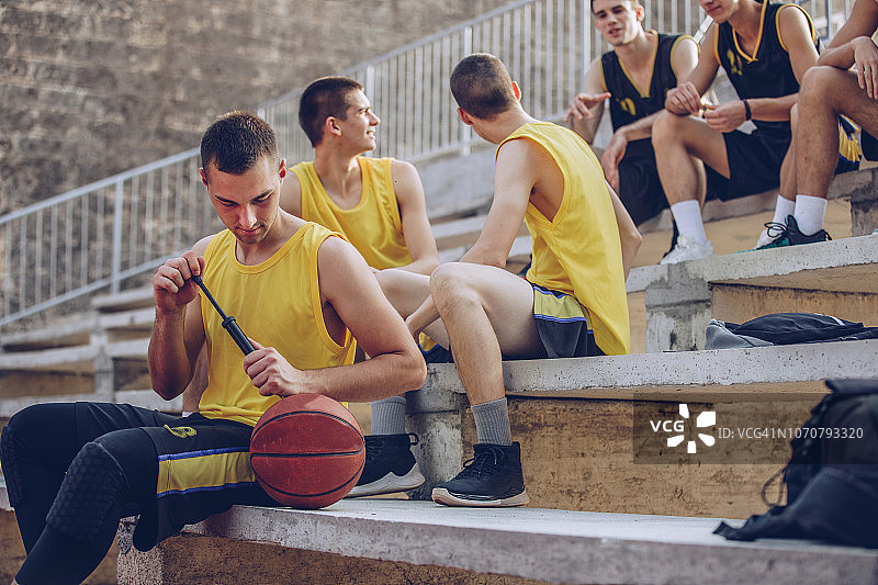 篮球运动员给篮球充气图片素材