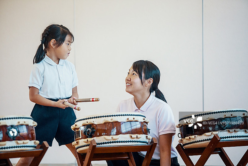 年轻女孩在日本的幼儿园练习传统太鼓图片素材