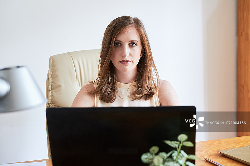 工作台前的年轻严肃的女商人图片素材