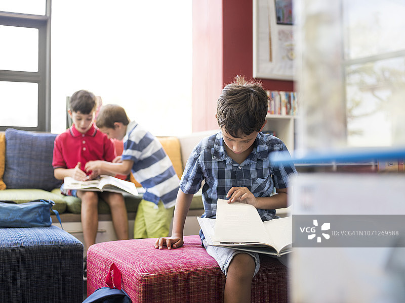 男孩在小学图书馆里看书图片素材