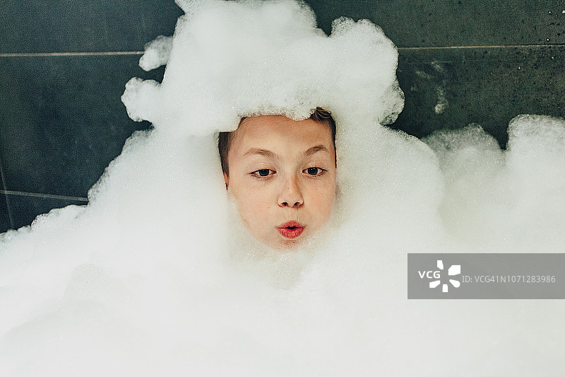 在泡泡浴中放松的男孩图片素材