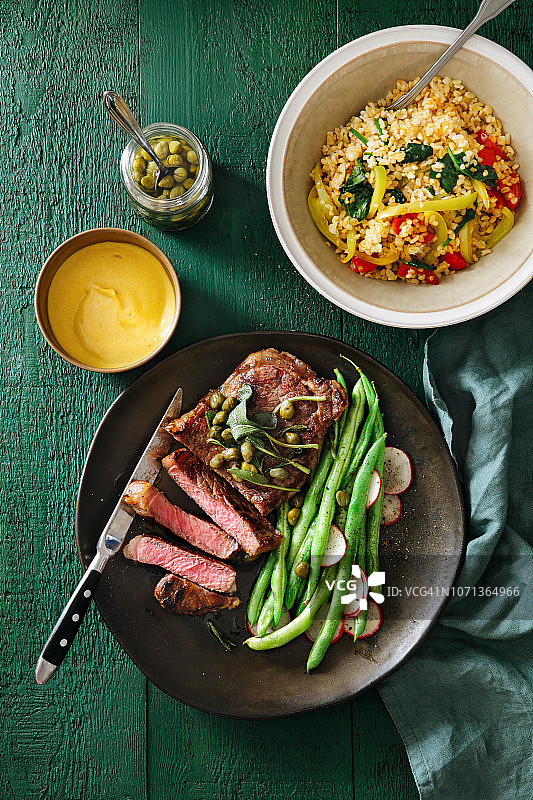 搭配芥末酱、蔬菜、香草和刺山柑的牛排图片素材