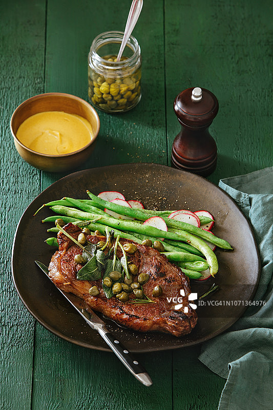 搭配芥末酱、蔬菜、香草和刺山柑的牛排图片素材