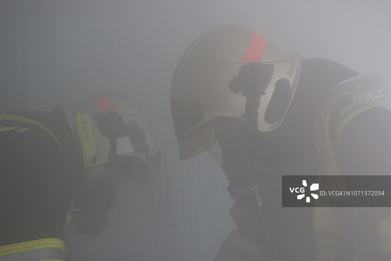 烟雾中工作的两名消防员图片素材