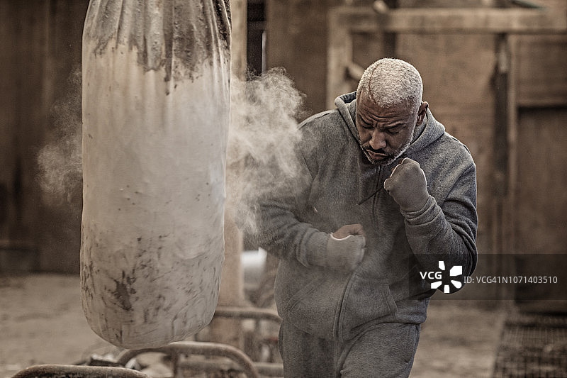 在废弃农场锻炼的中年黑人拳击手图片素材