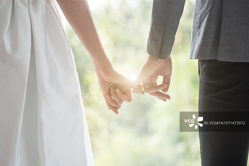 婚礼派对上新郎新娘手比爱心图片素材