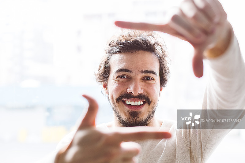 微笑男子用手取景图片素材