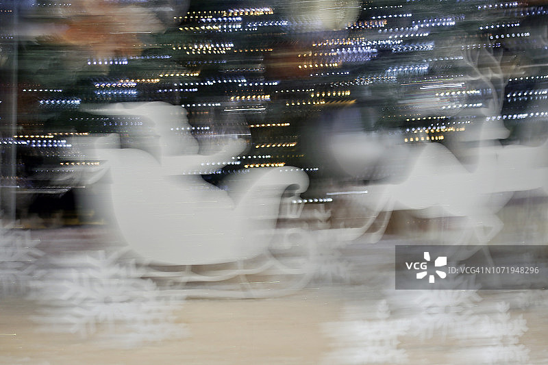 圣诞老人坐在驯鹿拉的雪橇上在雪地上奔跑图片素材