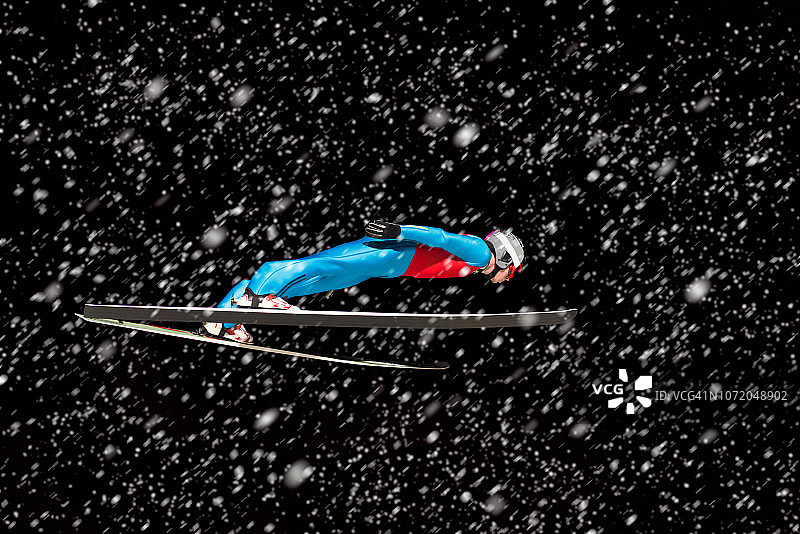 暴风雪中空中滑雪跳远运动员侧面图片素材