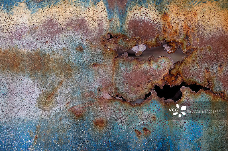 刮擦汽车上的带孔生锈盘子图片素材