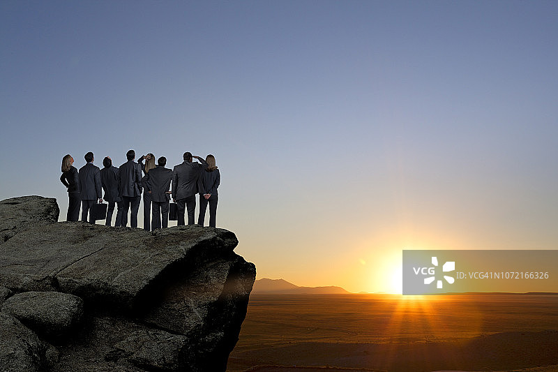一群商务人士站在海角眺望日落图片素材
