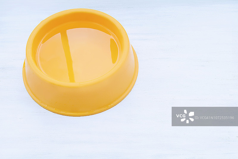 盛满水的黄色塑料碗图片素材