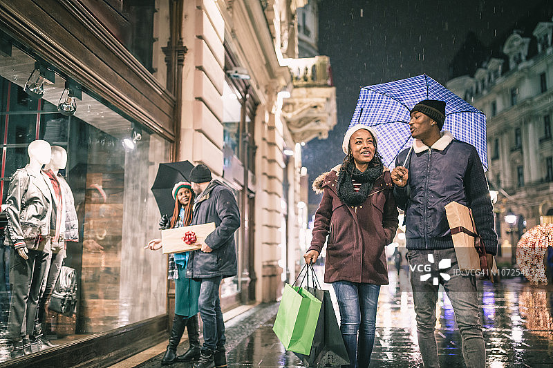 两对年轻情侣享受圣诞购物图片素材