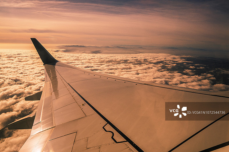 日落时分波音飞机机翼上的云朵鸟瞰图图片素材