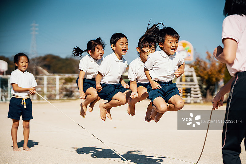幼儿和小朋友在老师的指导下跳绳图片素材