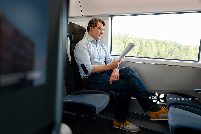 男子在火车上阅读旅行指南图片素材
