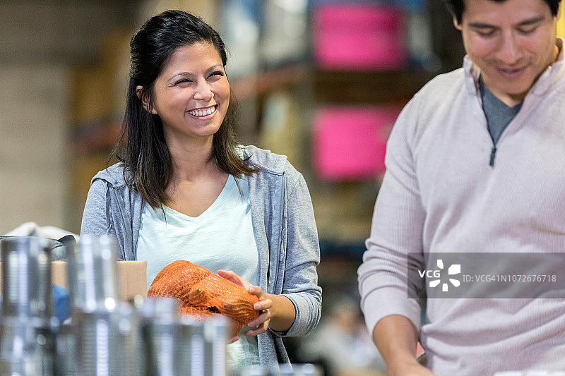 年轻情侣站在桌子前微笑，一起做志愿者图片素材