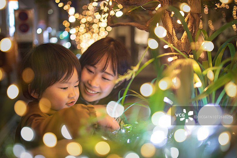 和妈妈一起玩圣诞灯的小男孩图片素材