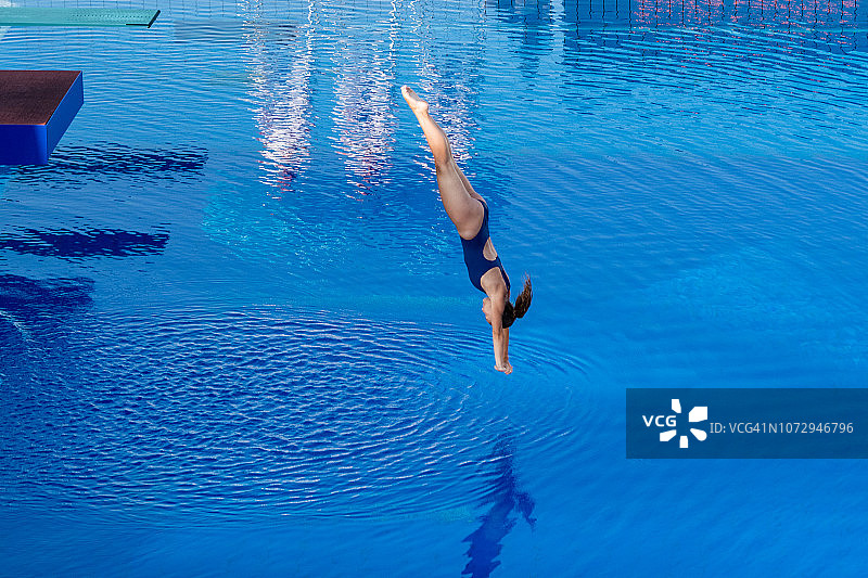 年轻女人在游泳池里潜水图片素材