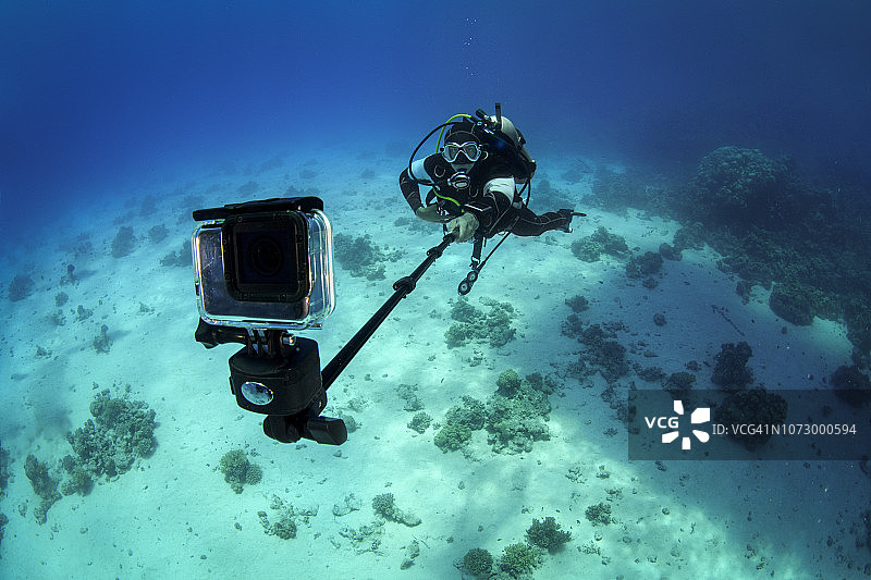 潜水员在水下使用GoPro自拍杆图片素材