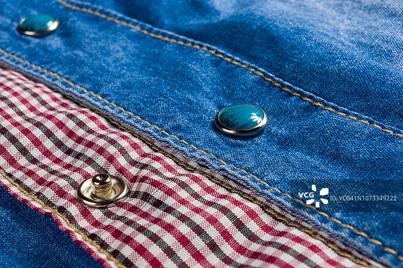 带有接缝、扣环、纽扣和铆钉的蓝色水洗褪色牛仔裤纹理图片素材