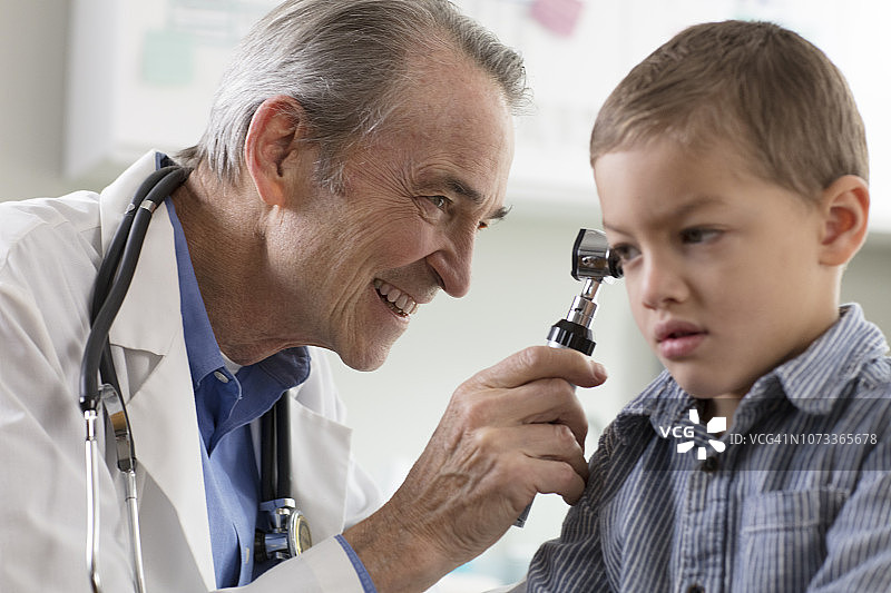 年长的儿科医生在医疗诊所检查小男孩图片素材