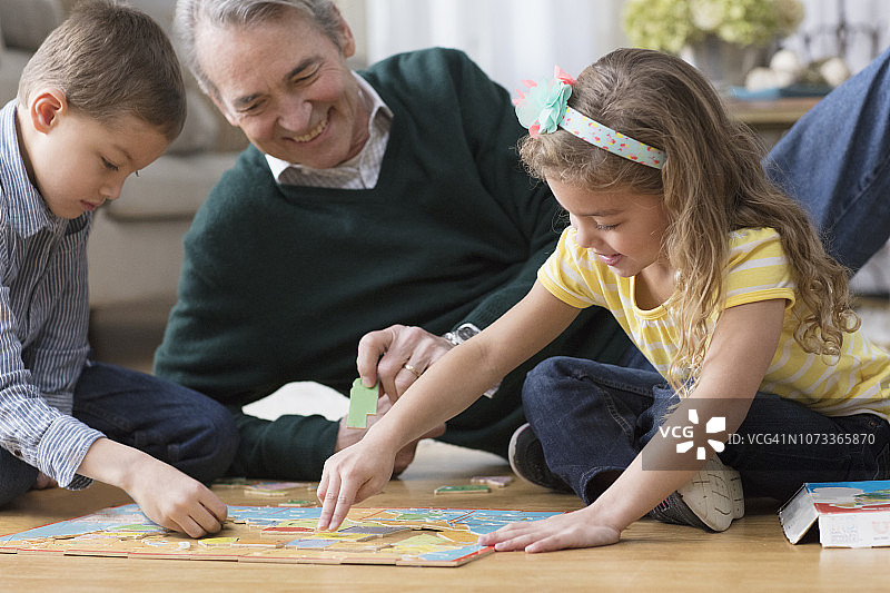 爷爷和孙子们一起拼拼图图片素材