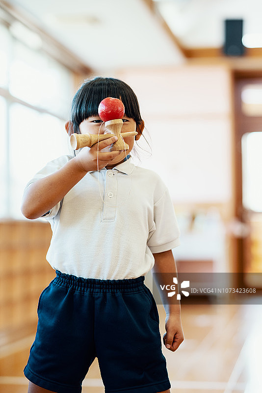 幼儿园里玩剑玉的年轻女孩肖像图片素材