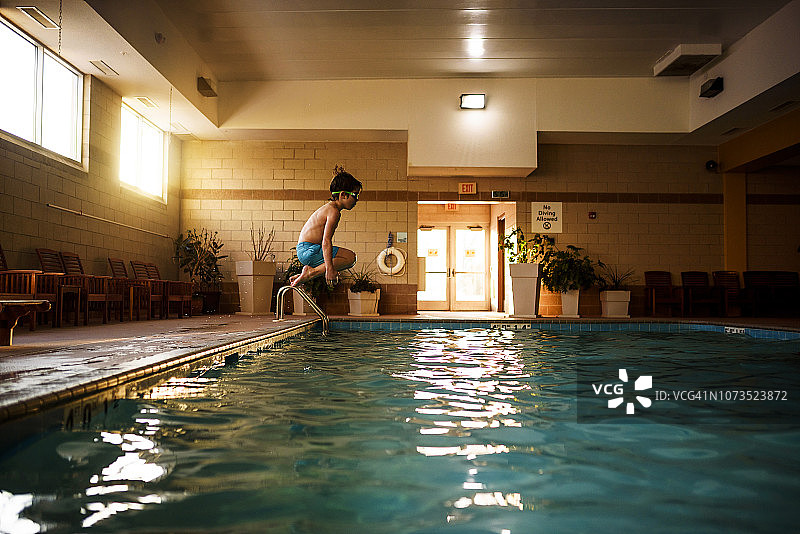 男孩跳进游泳池图片素材