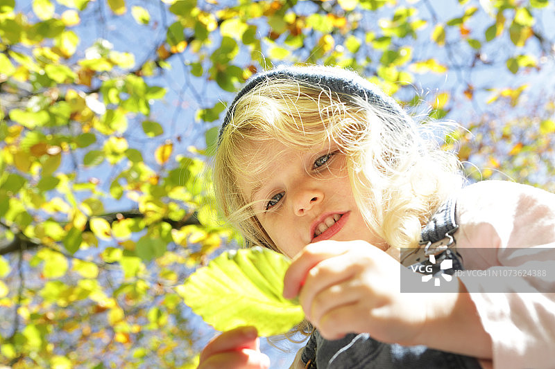看秋叶的年轻女孩图片素材