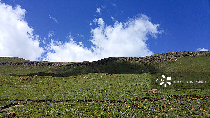 南非自由州克拉伦斯金门高地国家公园的岩层上的蓬松云朵图片素材