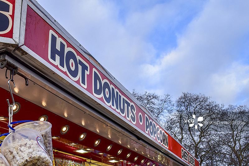 英国克拉珀姆公地游乐场的热甜甜圈和爆米花标志图片素材