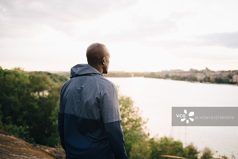 站在山丘上面朝大海的男人图片素材