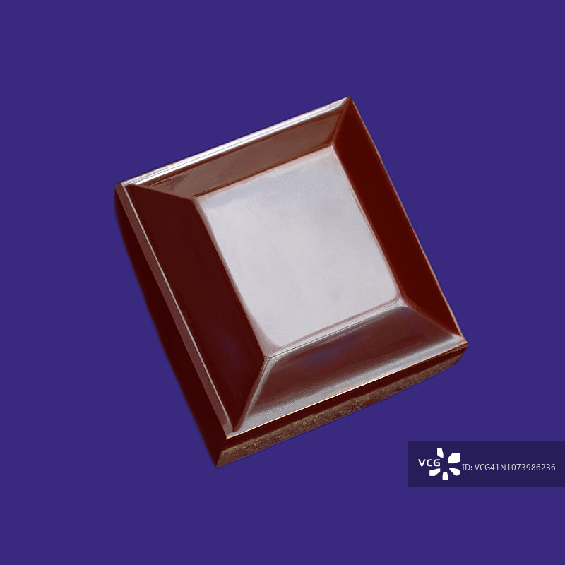 紫色蓝色背景上的单块黑巧克力图片素材