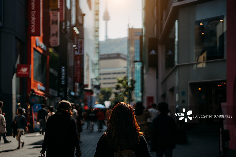 年轻的亚洲女性在韩国首尔明洞街头市场旅行和购物。图片素材