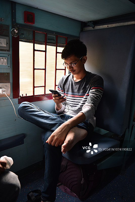 青少年男孩在火车上使用手机图片素材
