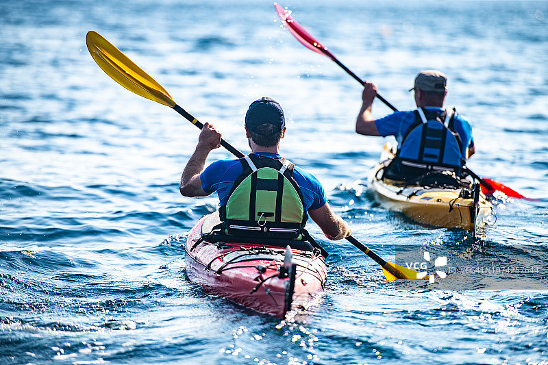 皮划艇爱好者在海上共同划桨图片素材