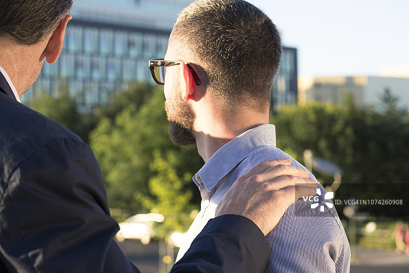 年长的商人将手放在年轻商人的肩膀上图片素材